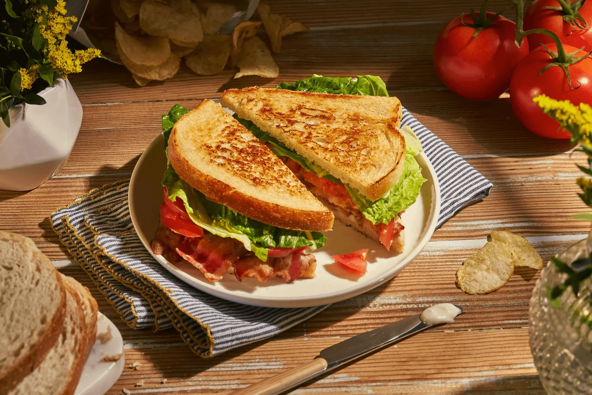 Sourdough BLT sandwich cut in half served on a plate