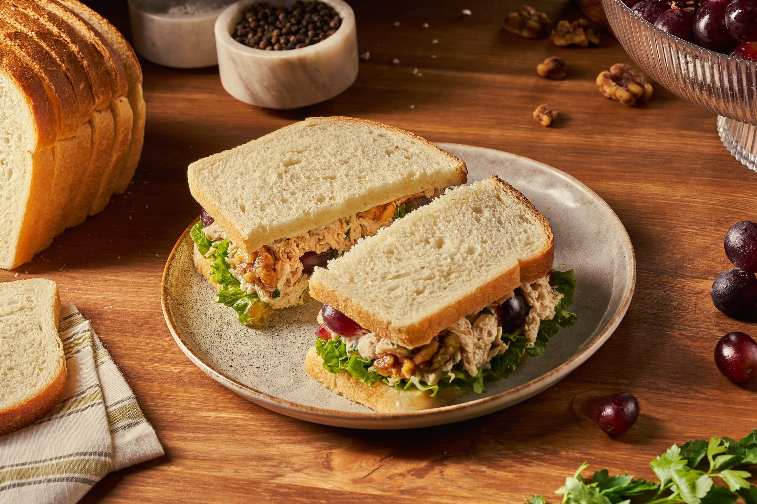 hearty chicken salad on sliced izzio sourdough sandwich bread with lettuce on neutral plate loaded with