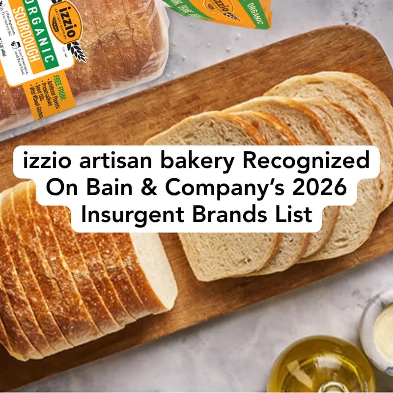 Loaf of bread on cutting board. Izzio bread package, and olive oil and butter containers