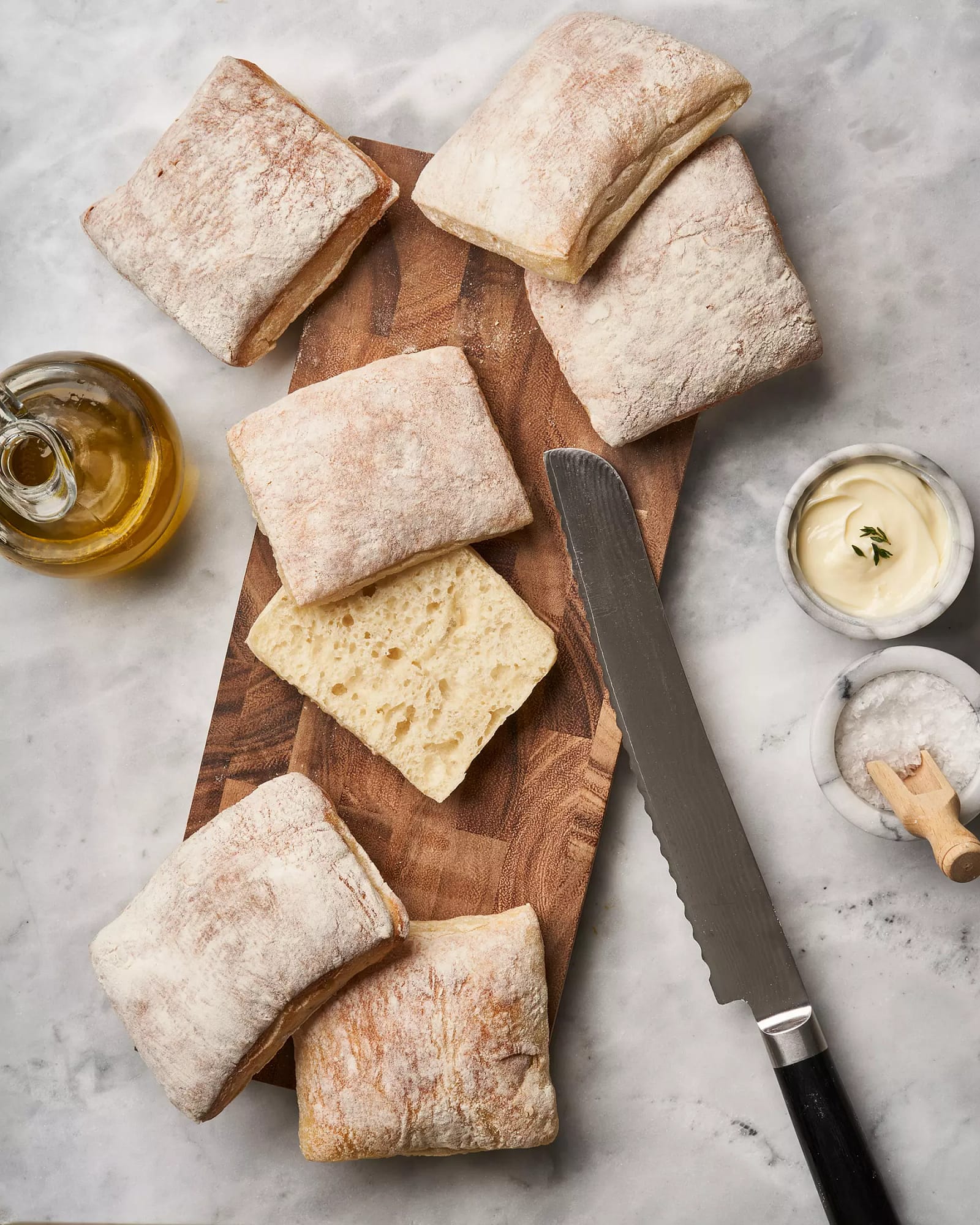 Italian sandwich rolls sliced on a wooden cutting board
